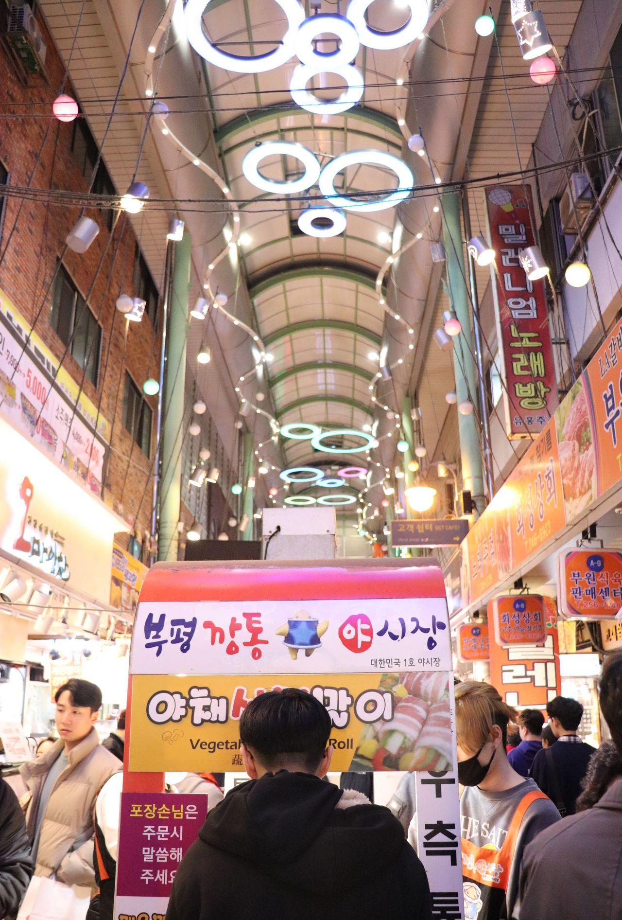 富平市場的入口，購物者忙碌地穿梭於店鋪之間的夜市情景